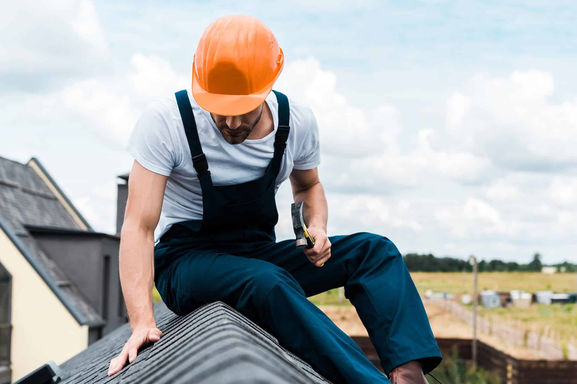 Homeowner inspecting a roof for winter damage during spring.