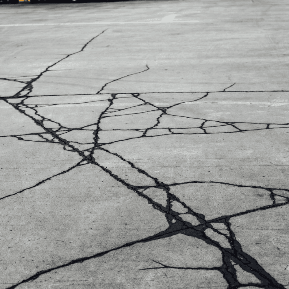 Concrete slab with extensive interconnected cracks across its surface