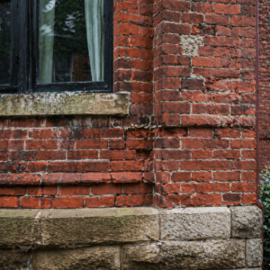Historic Toronto brick wall with original masonry details and visible areas needing careful restoration