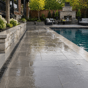 Toronto poolside masonry area with visible drainage slope and clean water runoff design