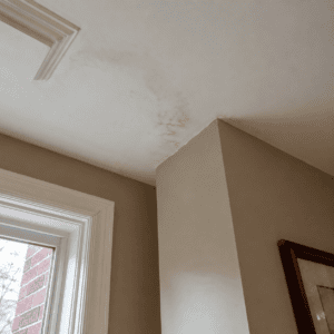 Interior ceiling water stain near a chimney caused by possible flashing problems