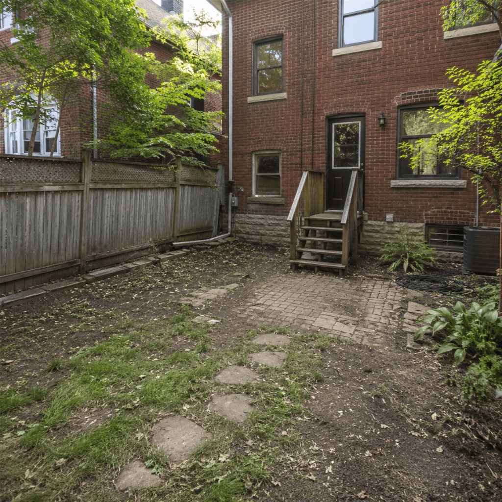 Backyard patio area with brick pavers, stepping stones, wooden stairs, and brick home exterior