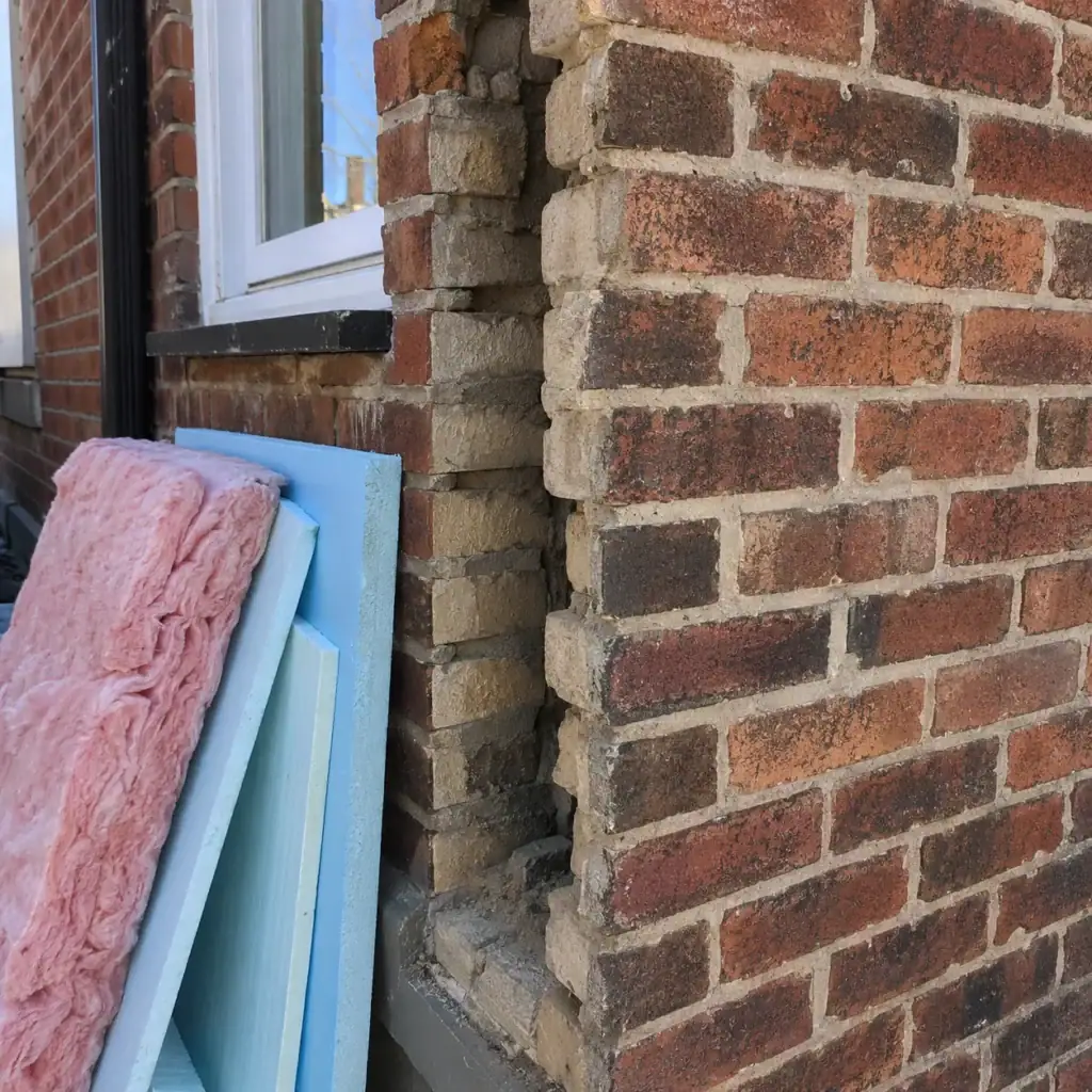 Older Toronto brick wall showing masonry beside insulation materials