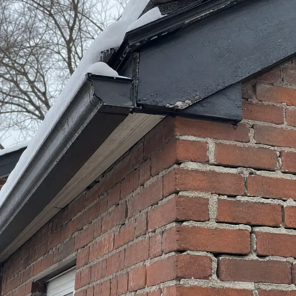 Open mortar joints in roofline brickwork during winter