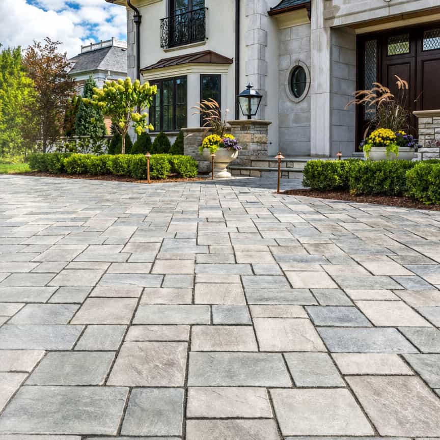 Beautiful stone paved driveway in front of a luxurious home.