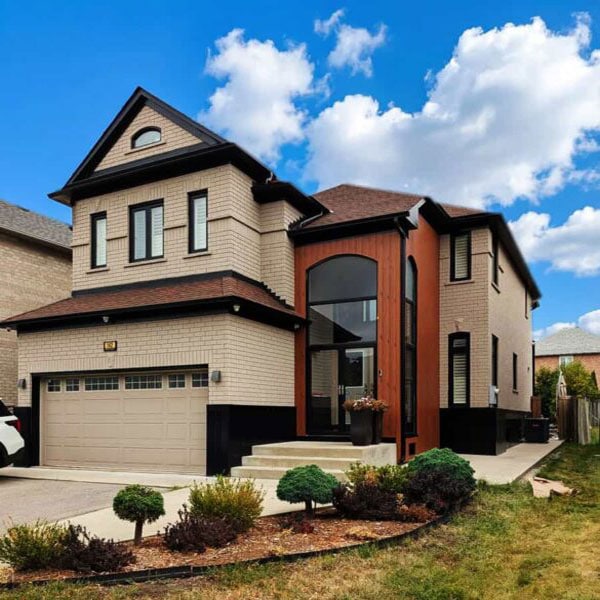 Contemporary house with brick and wood accents under a blue sky.