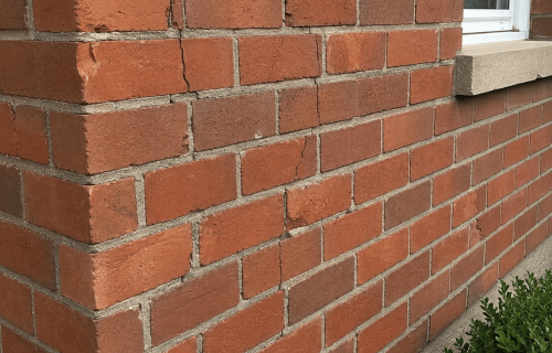 Damaged brickwork on building corner.