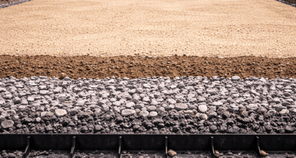 Compactor leveling an aggregate base during driveway preparation