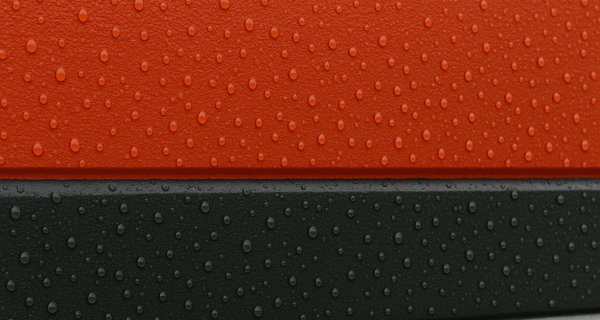 Water droplets bead across red, black, and gray textured surfaces
