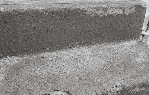 Weathered concrete steps with surface spalling.