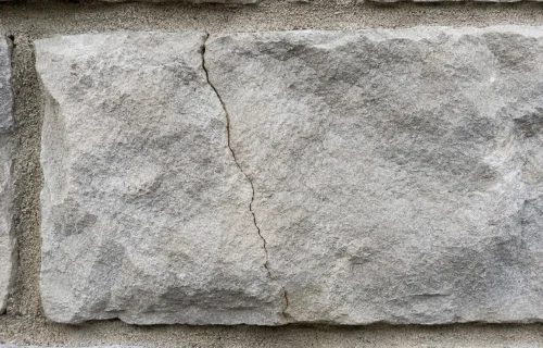 Crack running through a stone veneer piece on an exterior wall